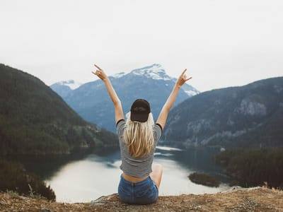 顯化是什麼？：金髮女子在山頂俯瞰山湖，象徵顯化理想生活與內在力量，提升顯化法則實作效率。